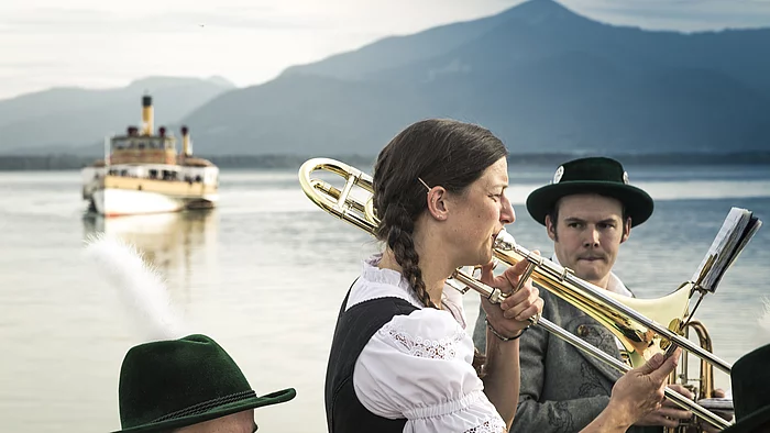 Kultur am Chiemsee Musiker vor der Kulisse des Chiemsees mit einem Dampfer