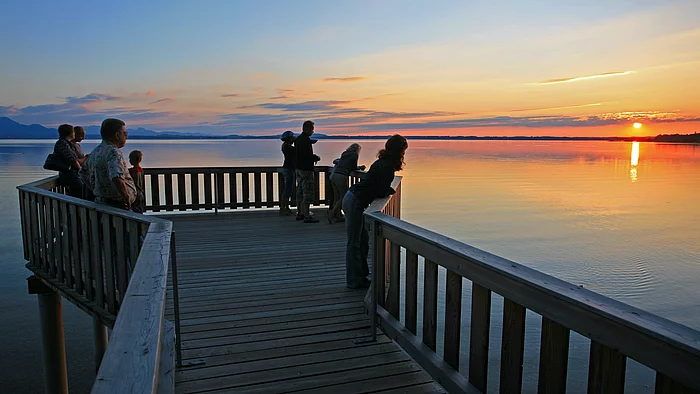 Naturbeobachtungsstation Personen auf der Naturbeobachtungsplattform Chieming während des Sonnenuntergangs