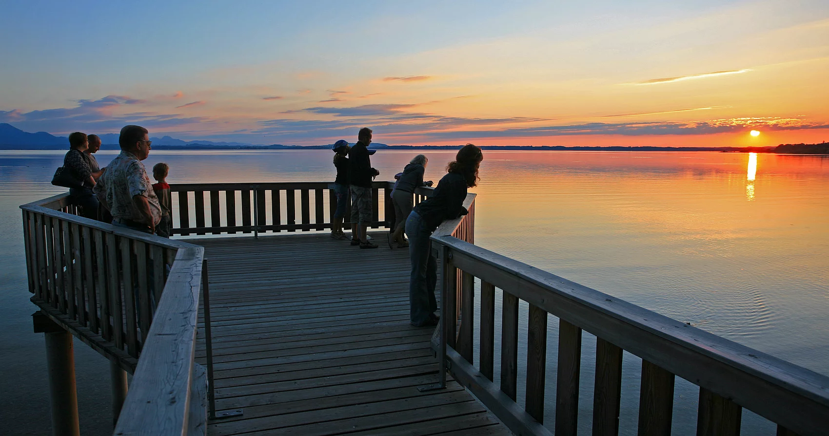 Naturbeobachtungsstation Personen auf der Naturbeobachtungsplattform Chieming während des Sonnenuntergangs